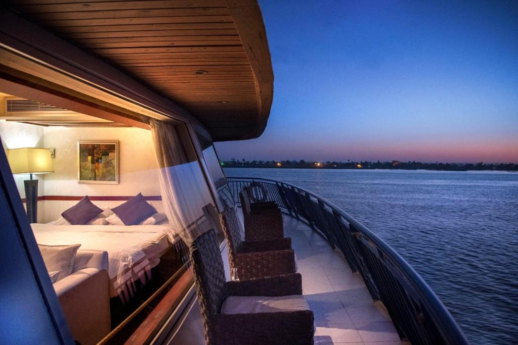 盧克索的住宿－Nile Cruise 3 & 4 & 7 Nights included abo Simbel tour，船上的一张床,享有水景