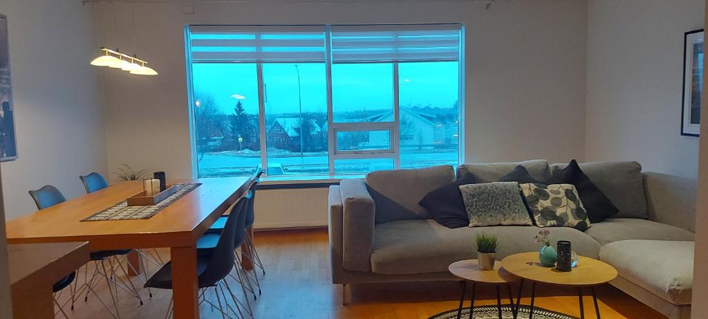 a living room with a couch and a table at Great apartment for families in Garðabær