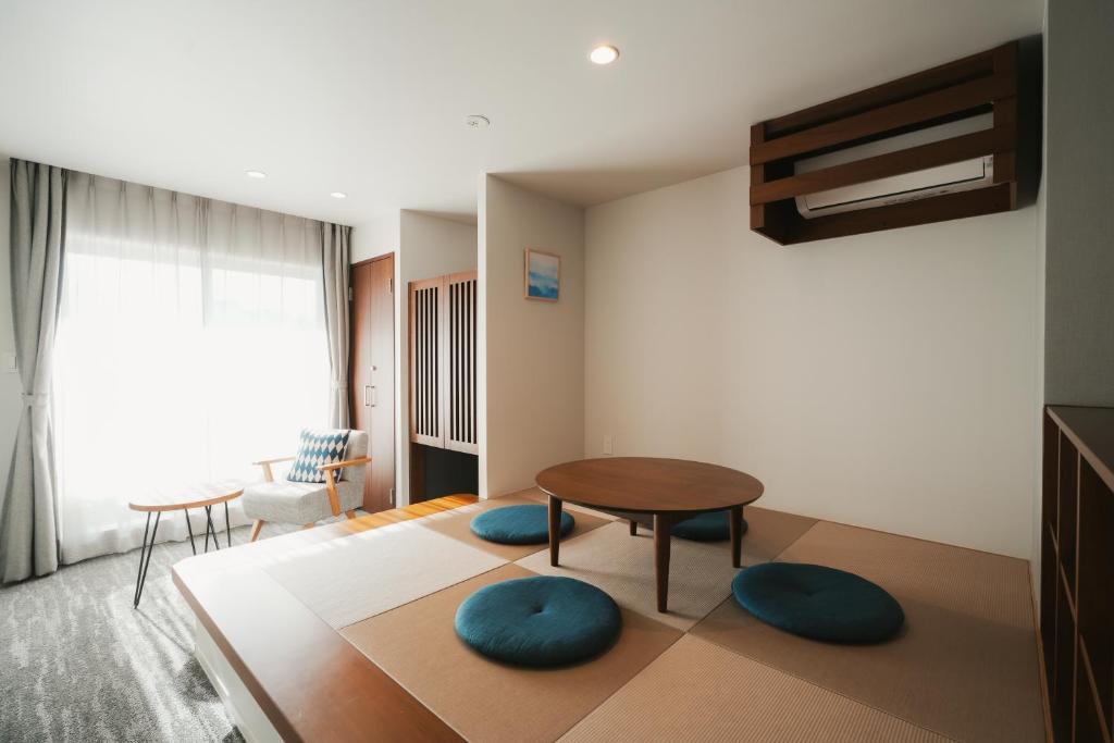 a living room with a table and two blue chairs at LAZULI Hiroshima Hotel and Lounge in Hiroshima
