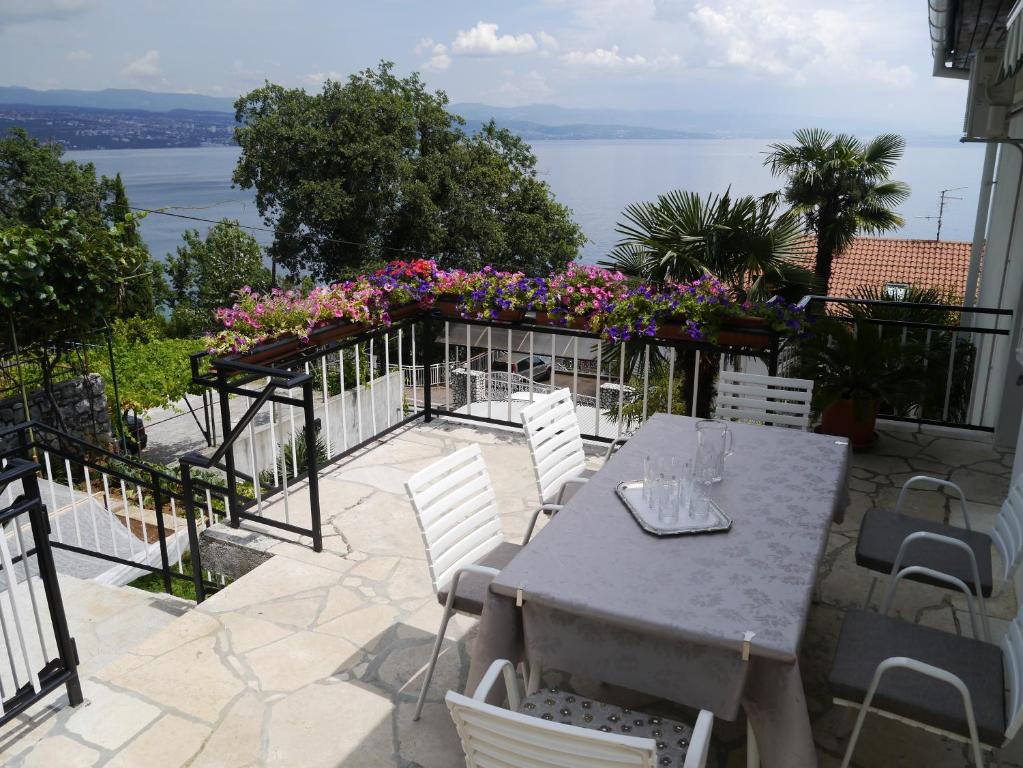 a table and chairs on a patio with a view of the water at Apartment Romana in Opatija