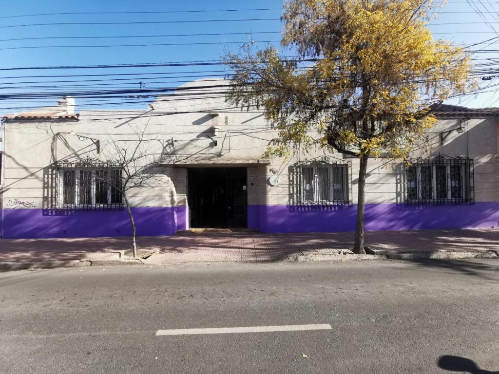 Un bâtiment violet avec un arbre devant lui dans l'établissement Hostería Residencial Santa Rosa, à Los Andes