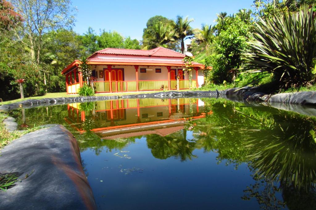 una casa con un estanque delante de ella en CASA DE CAMPO VILLA OLI!! - Un paraiso natural en la ciudad, en Villamaría