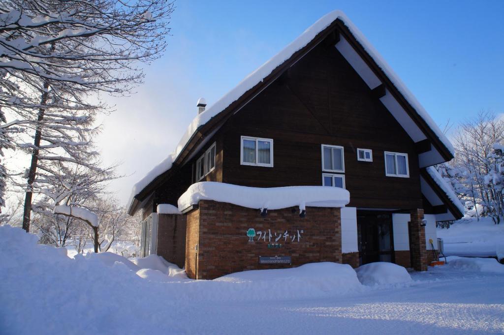 a building covered in snow with snow on it at Phytoncide Morinokaori in Furano
