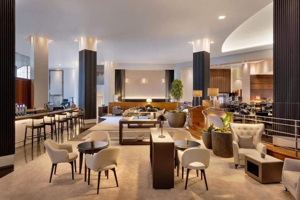 um átrio do hotel com mesas e cadeiras e um bar em JW Marriott Auckland em Auckland