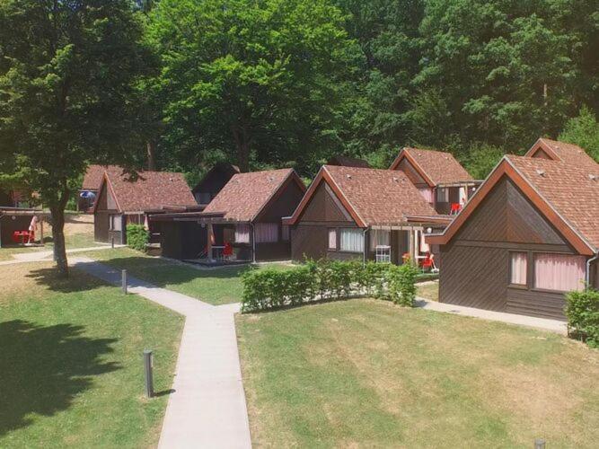 a group of houses in a yard with a sidewalk at Res Le Parc des Vosges du Nord, Bitche, holiday home for 5 pers in Bitche