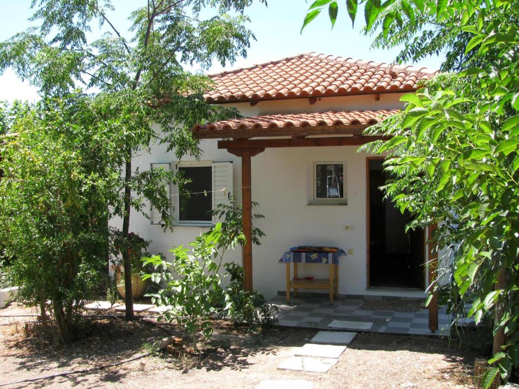 een klein wit huis met een rood dak bij Nikos 8 in Kakóvatos