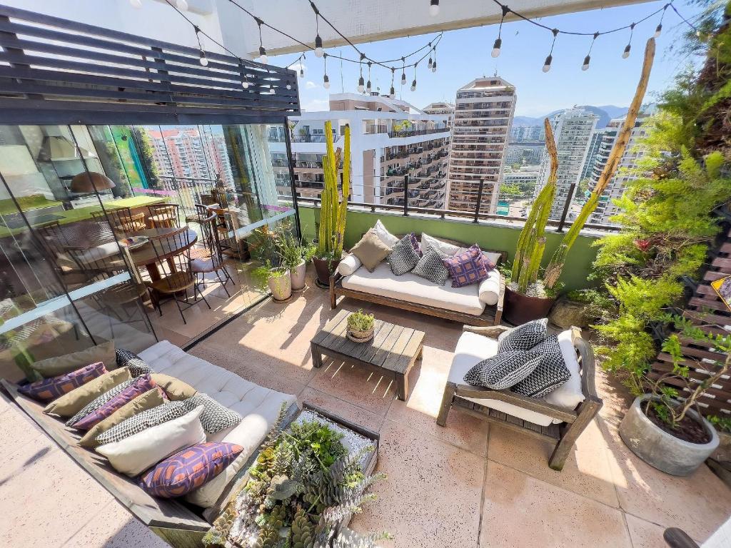 un patio al aire libre con sofás, mesas y plantas en Maravilhosa Cobertura com Vista Panorâmica, Piscina e varanda Gourmet B11-0012, en Río de Janeiro