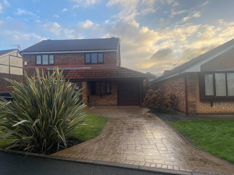 a brick house with a driveway in front of it at Modern home in quiet neighbourly street, perfect for Work From Home, quick links to centre in Manchester
