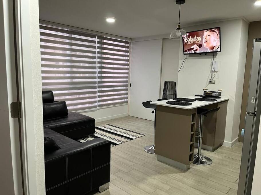 an office with a desk and a tv in a room at Depto nuevo en Santiago in Santiago