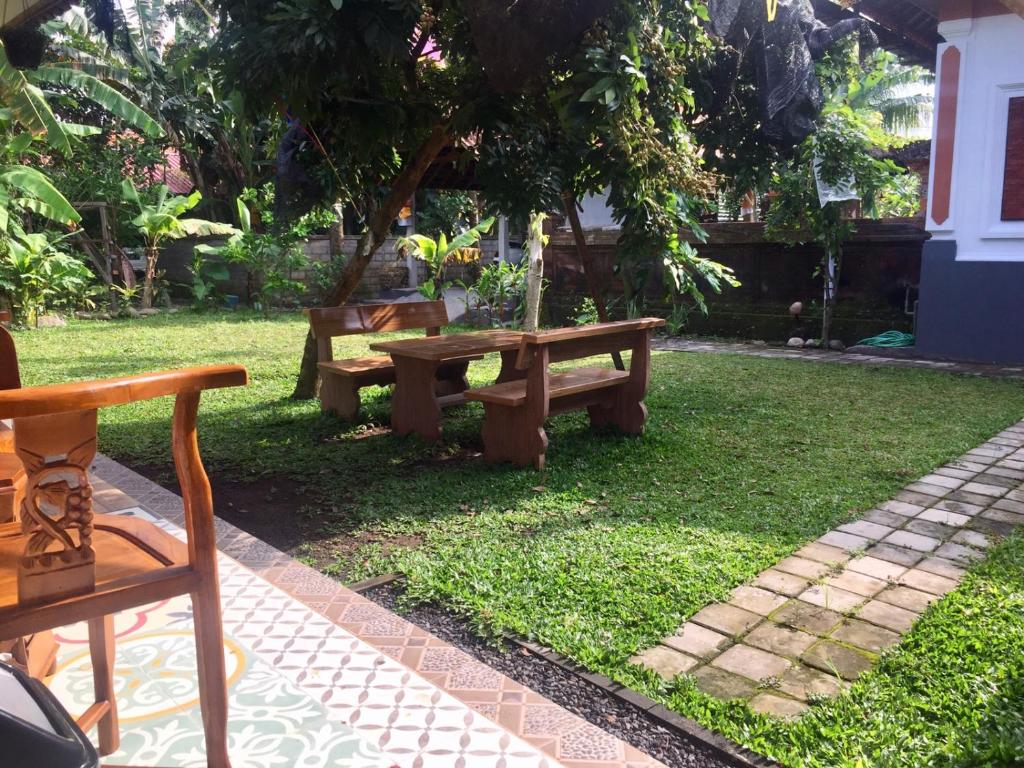 una mesa de picnic y un banco en un patio en Raditya Homestay en Mambal