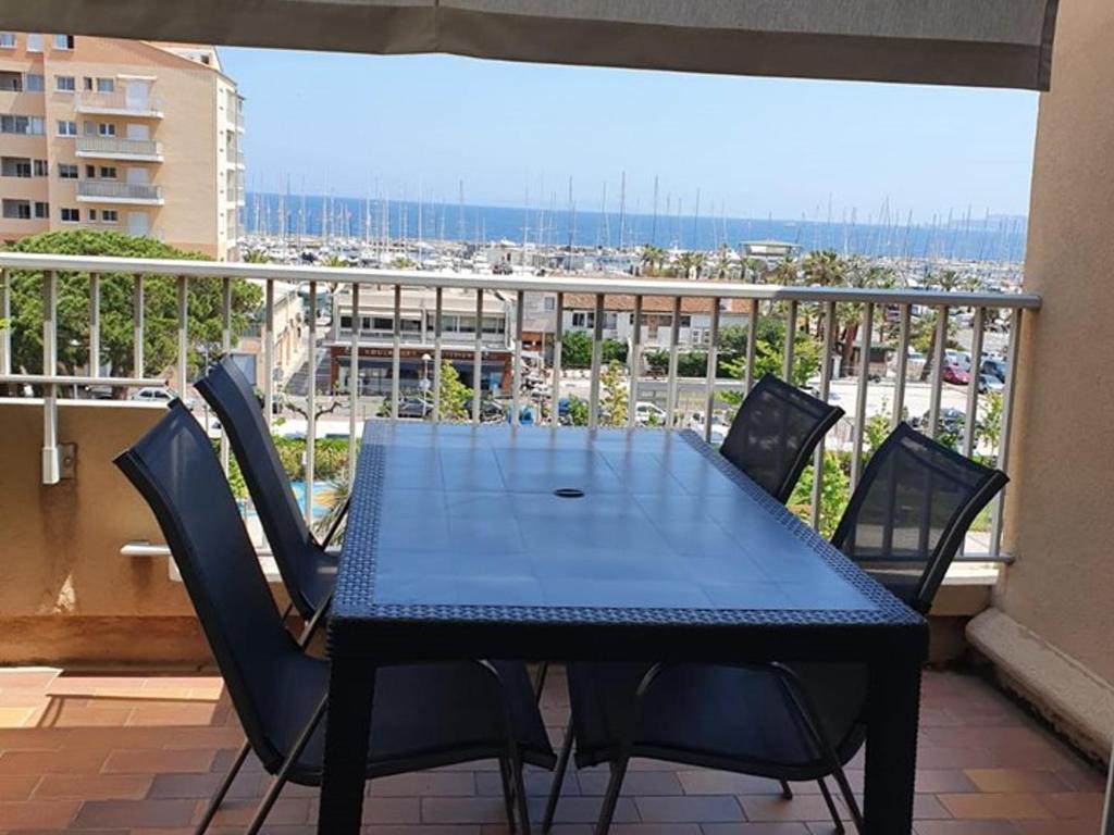 une table bleue et des chaises sur un balcon dans l'établissement Duplex Climatisé Hyères Port avec Terrasse, Parking et Wi-Fi - FR-1-335-179, à Hyères
