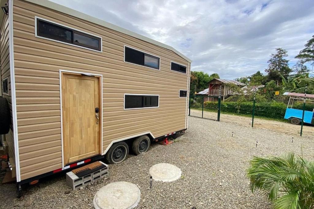 Tiny house with extended camping area for large groups في بويرتو فيجو: منزل صغير يجلس على الجزء الخلفي من مقطورة