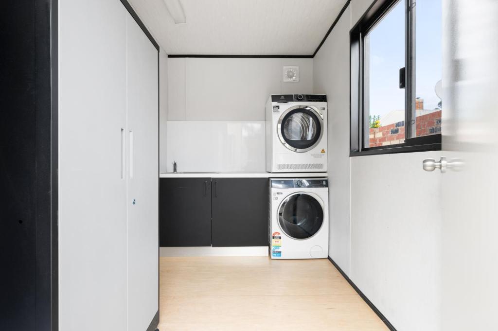 a laundry room with a washer and dryer in it at Collins Street Guest House in Kalgoorlie