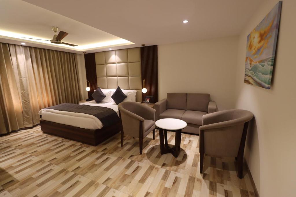 a hotel room with a bed and a couch at Mastiff Hotel Dhanbad in Dhanbād