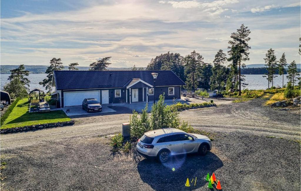 a house with a car parked in front of it at Awesome Home In Smedjebacken With House Sea View in Smedjebacken