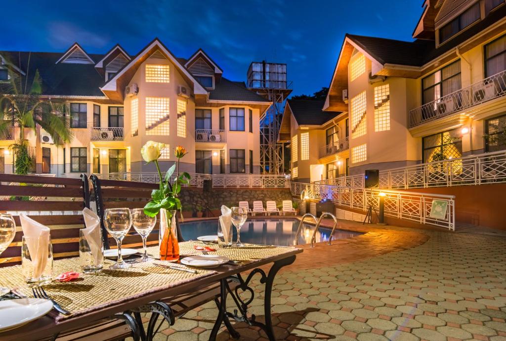 a patio with a table and chairs in front of a building at Gold Crest Hotel - Arusha in Arusha