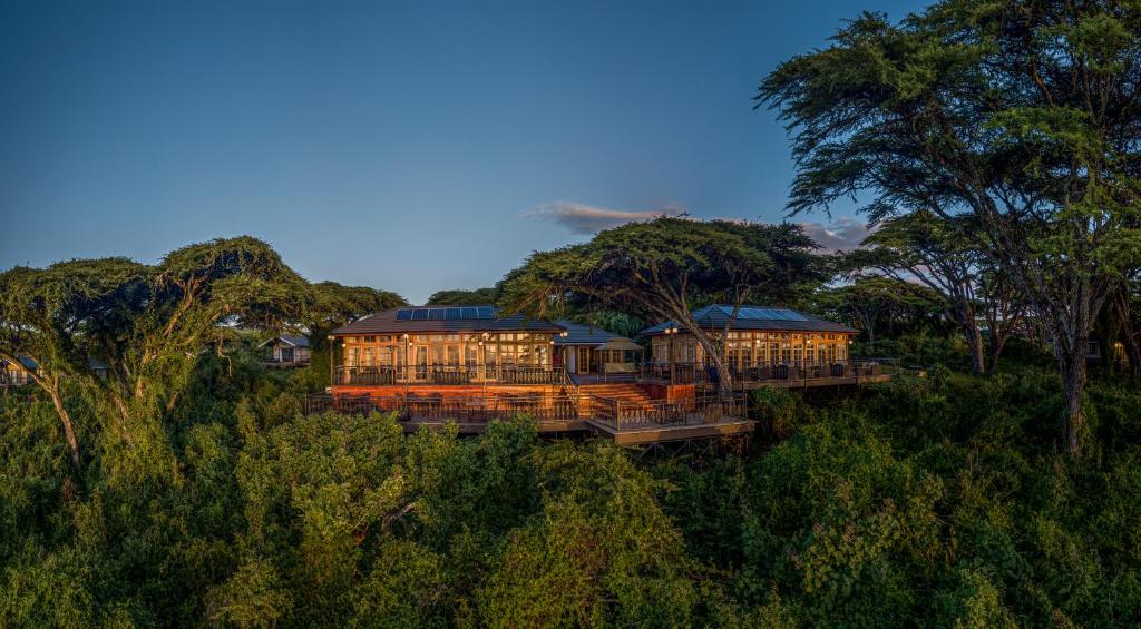 a house sitting on top of a hill with trees at Lions Paw Ngorongoro in Ngorongoro