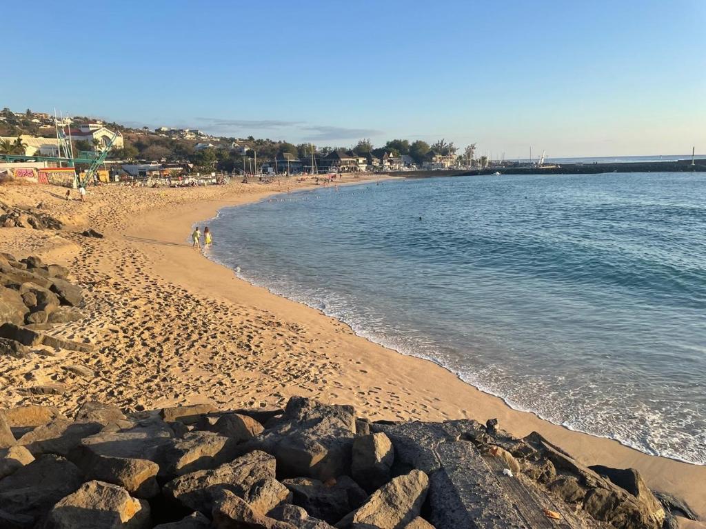 una playa de arena con rocas y el océano en La Croisette appartement vue mer à 1mn de la plage + parking, en Filaos