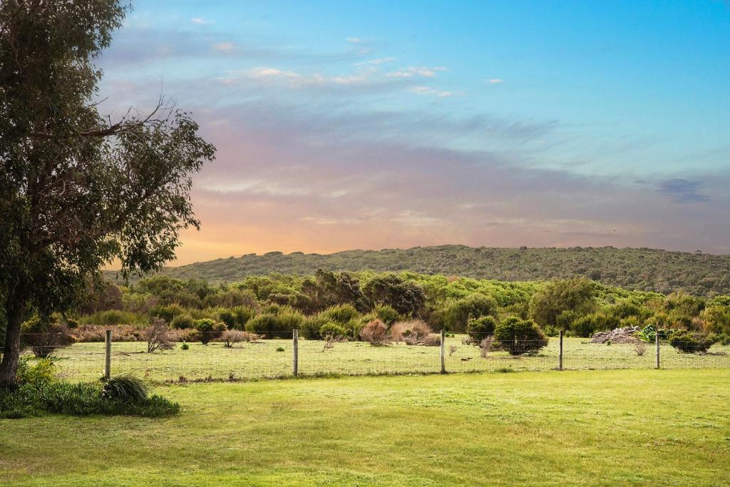 a field with a fence and trees in the distance at Rileystone in Margaret River Town
