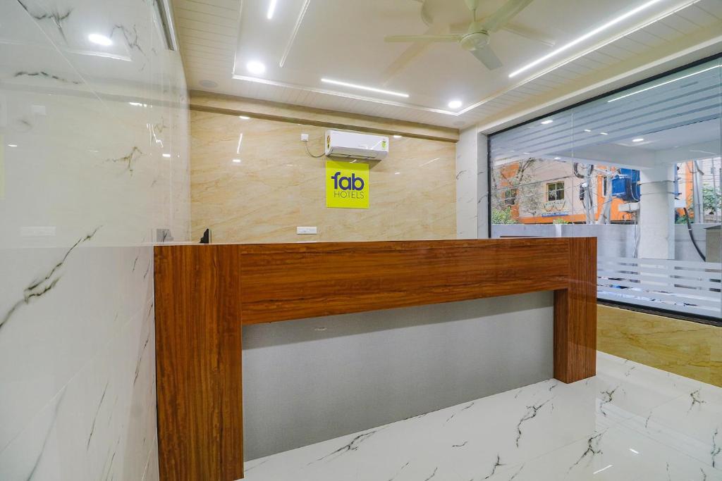 a reception desk in a room with a yellow sign on the wall at FabHotel Golden Hitech in Hyderabad