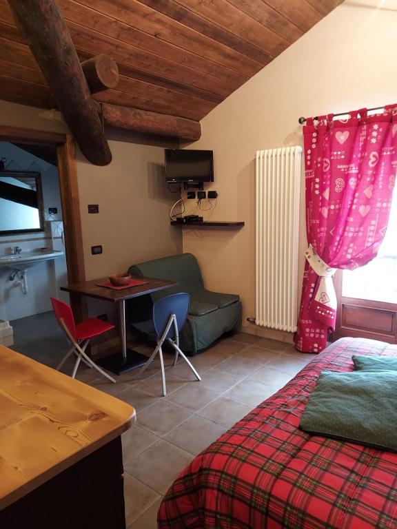 a bedroom with a bed and a table and a desk at Lauson in Cogne