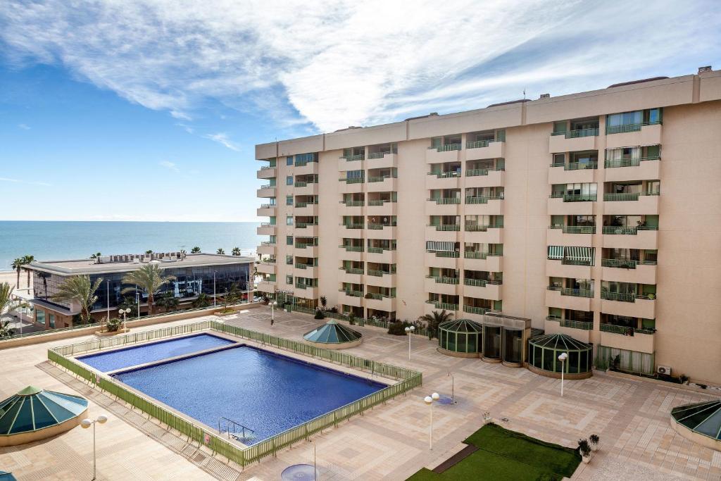 un hotel con piscina frente a un edificio en Valencia Flat Rental Patacona Beach, en Valencia