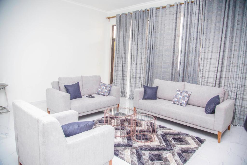ein Wohnzimmer mit 2 Sofas und einem Tisch in der Unterkunft Longhorn Executive Apartments in Lusaka