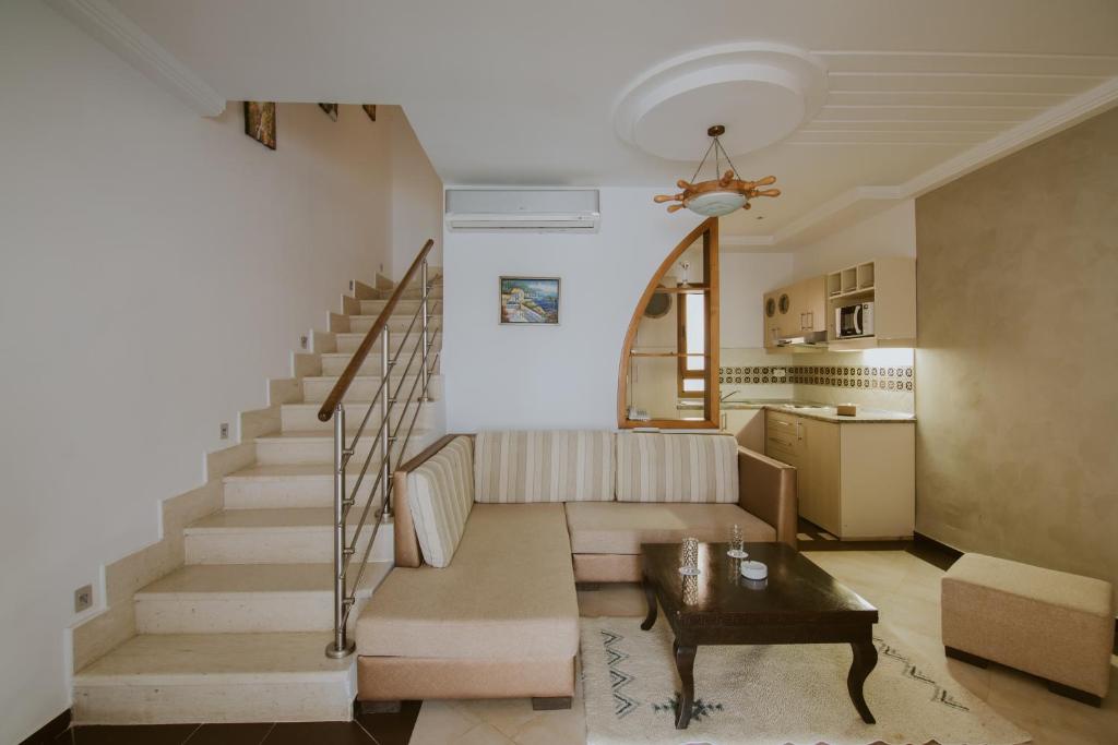 a living room with a staircase and a table at Palm Djerba Suites in Mezraya