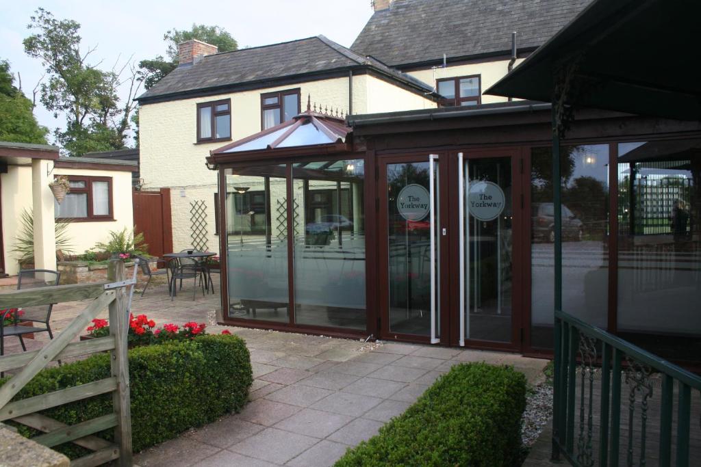 aconservatory with glass doors in front of a house at Yorkway Motel in Pocklington