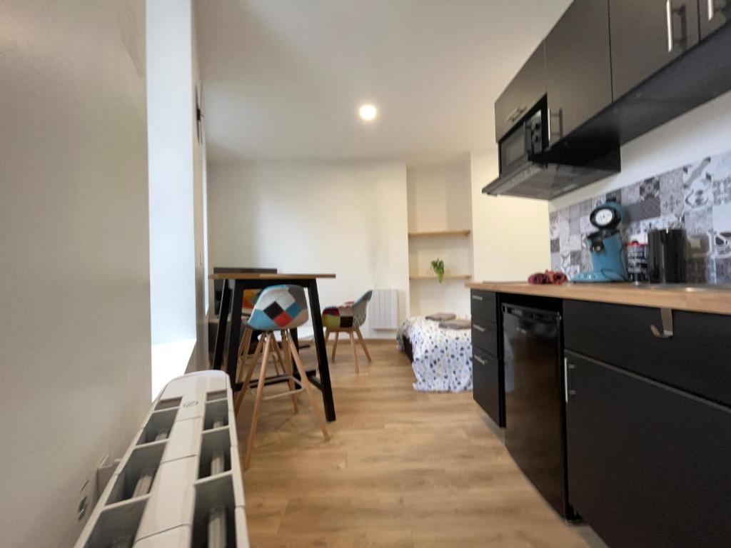 uma cozinha com um balcão e uma mesa num quarto em Le Montgy - Studio tout confort à Royat National N1 em Royat