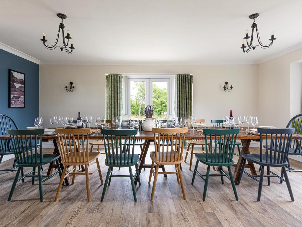 a dining room with a large wooden table and chairs at Banbury Hill Farmhouse in Charlbury