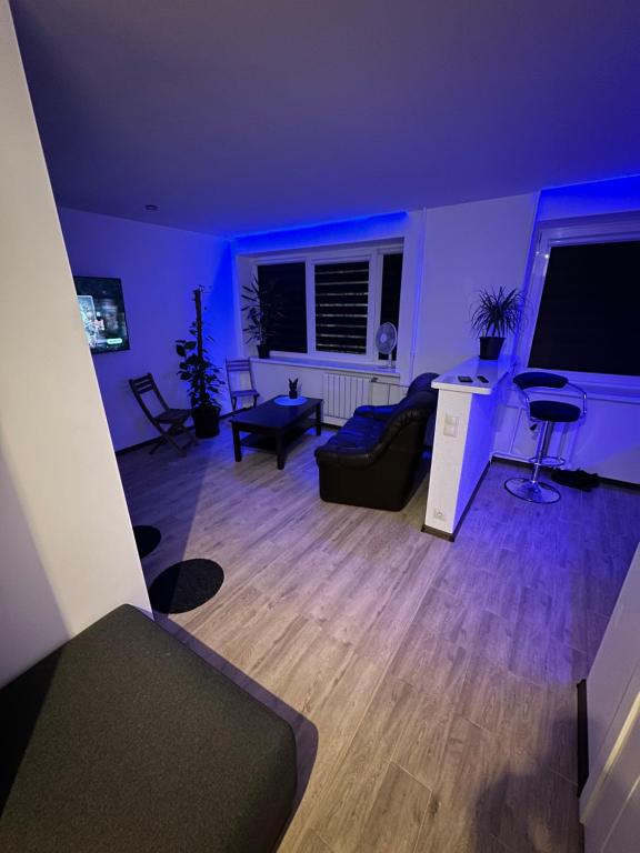 uma sala de estar com luzes roxas numa sala de estar em Studio apartment em Valmiera