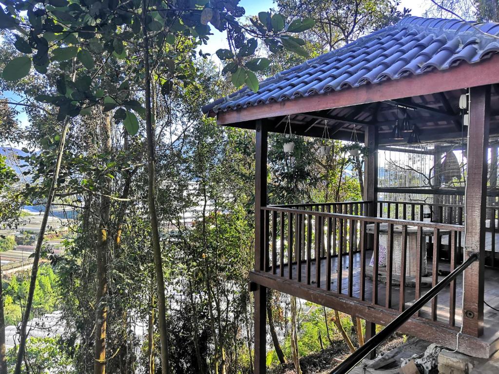 a wooden gazebo with a view of a forest at Orkid Chalet in Cameron Highlands