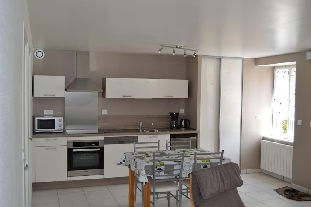 une cuisine avec une table et une salle à manger dans l'établissement maison de vacances Nébouzat, à Nébouzat