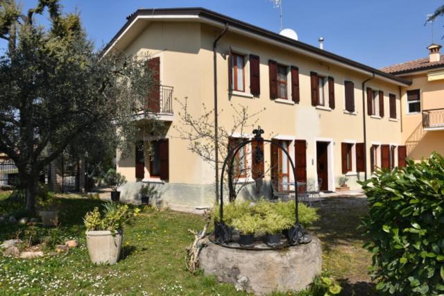 una casa con un cortile con delle piante davanti di Casa Olinda a Lazise