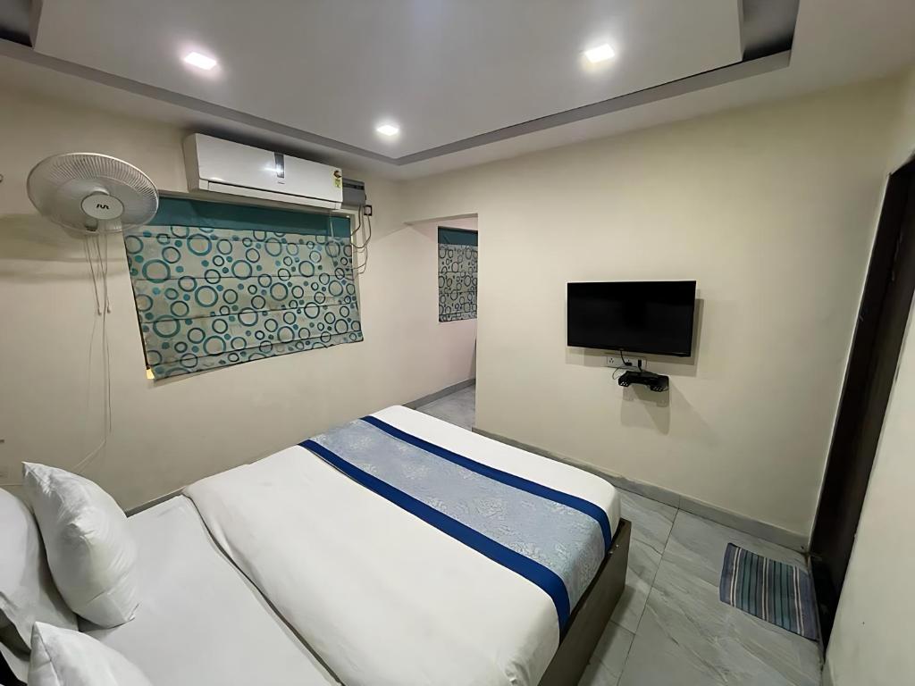 a small bedroom with a bed and a tv at Hotel Baba - near Charbagh Railway Station in Lucknow