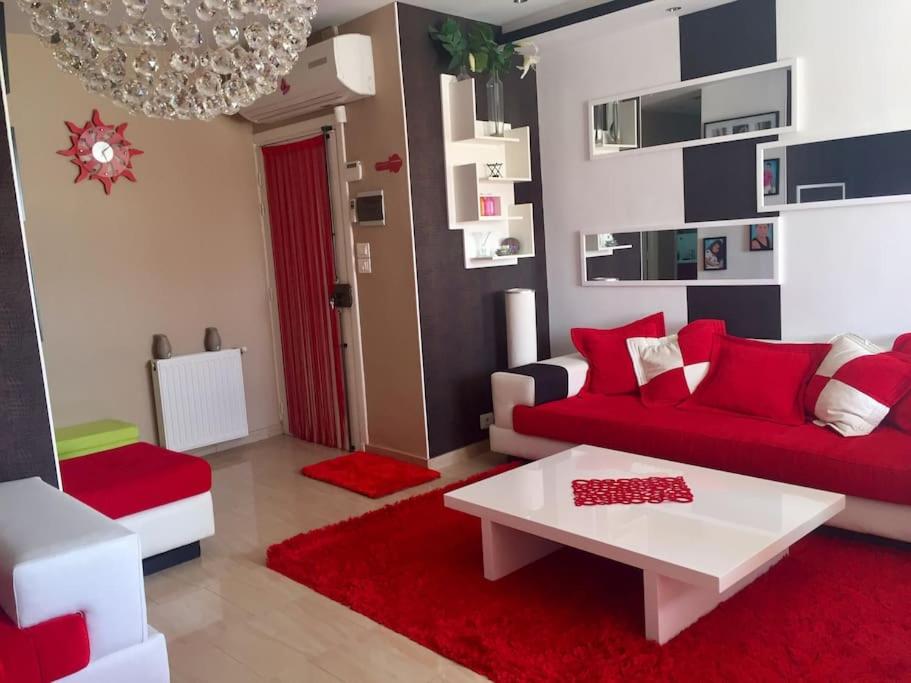 een woonkamer met een rode bank en een tafel bij Belle appartement 3 pièces à 500m de la plage in Nabeul