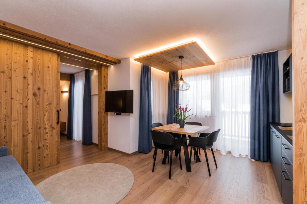 una cucina e una sala da pranzo con tavolo e sedie di Residence Maximilian a Valdaora