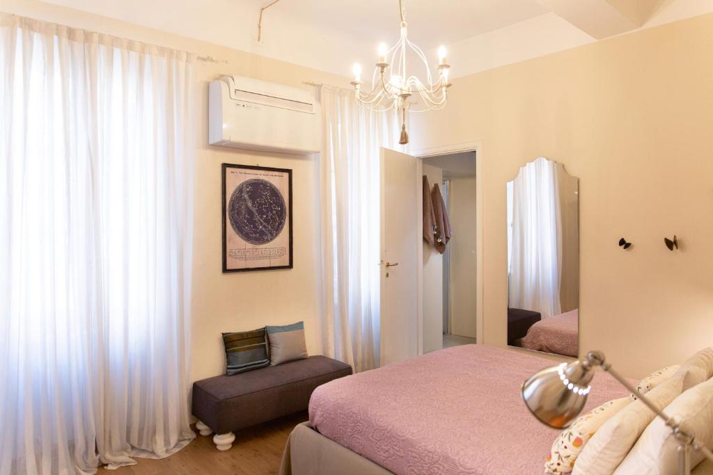 sypialnia z łóżkiem, krzesłem i żyrandolem w obiekcie Casa delle Stelle Luxury w Lukce