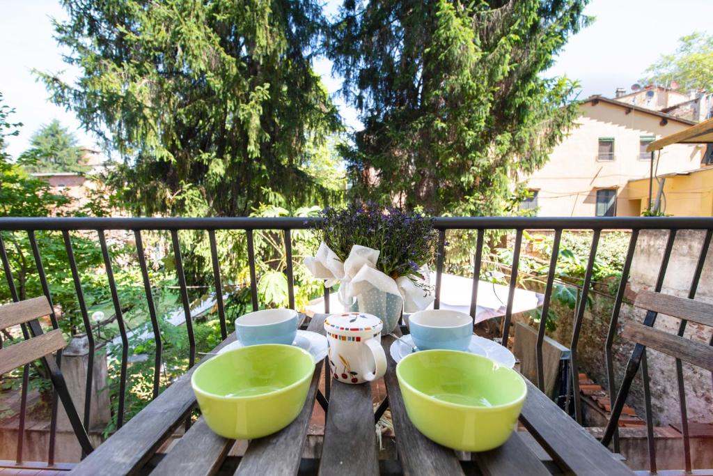 einen Holztisch mit zwei grünen Schalen auf dem Balkon in der Unterkunft Re Migio Apartment with Terrace and Lift in Lucca