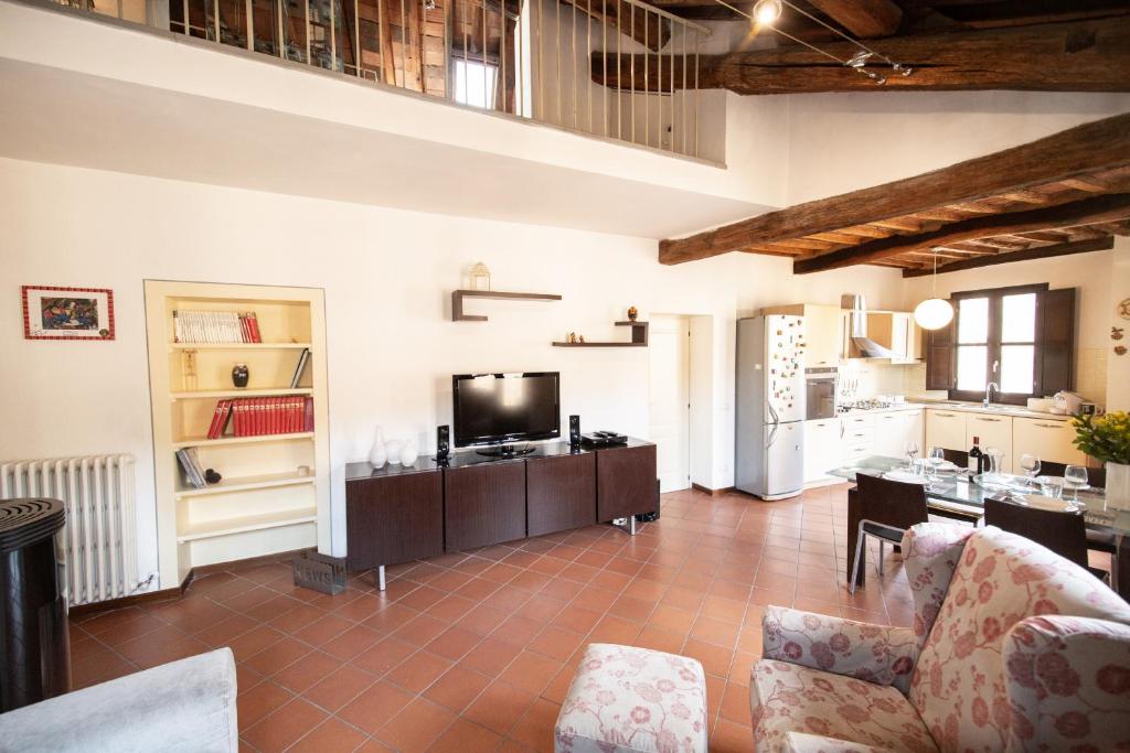 ein Wohnzimmer mit einem Sofa und einem TV in der Unterkunft Serena Apartment, Cosy Close Center Town in Lucca