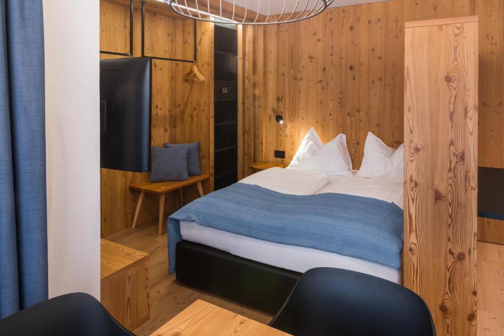una camera con un letto in una stanza con pareti in legno di Residence Maximilian a Valdaora