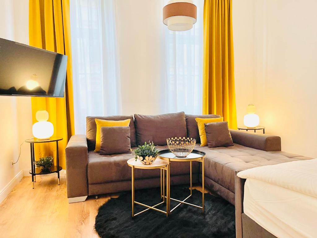 - un salon avec un canapé et une table dans l'établissement Apartment Maximilian, à Vienne