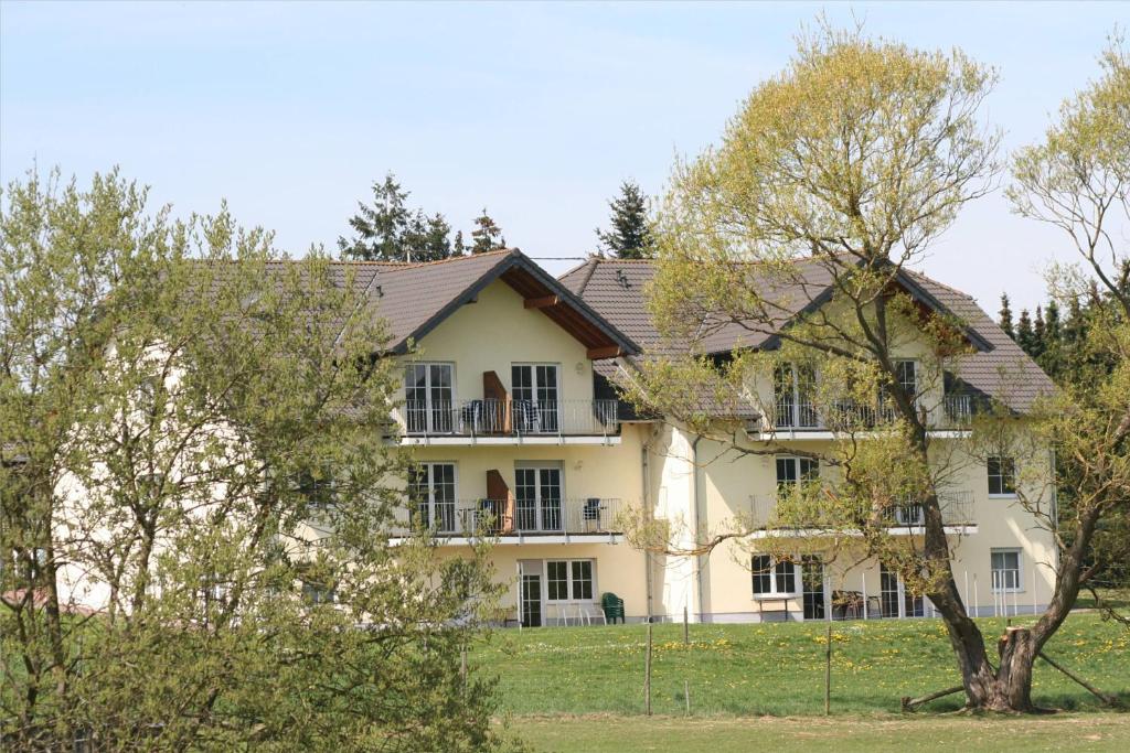 ein großes weißes Haus mit einem Zaun davor in der Unterkunft Ferienwohnung Sonneck in Kelberg