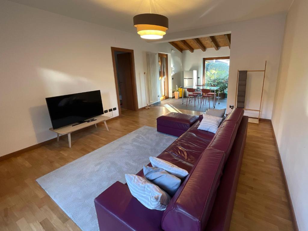 ein Wohnzimmer mit einem Sofa und einem Flachbild-TV in der Unterkunft Kikka's gem - Spacious Apartment 20km from Milan in Seregno