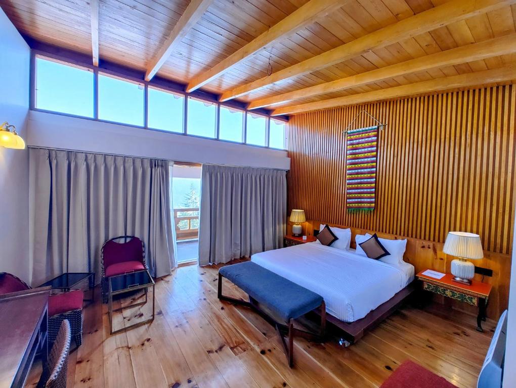a bedroom with a large bed and a large window at Timilo Boutique in Tawang