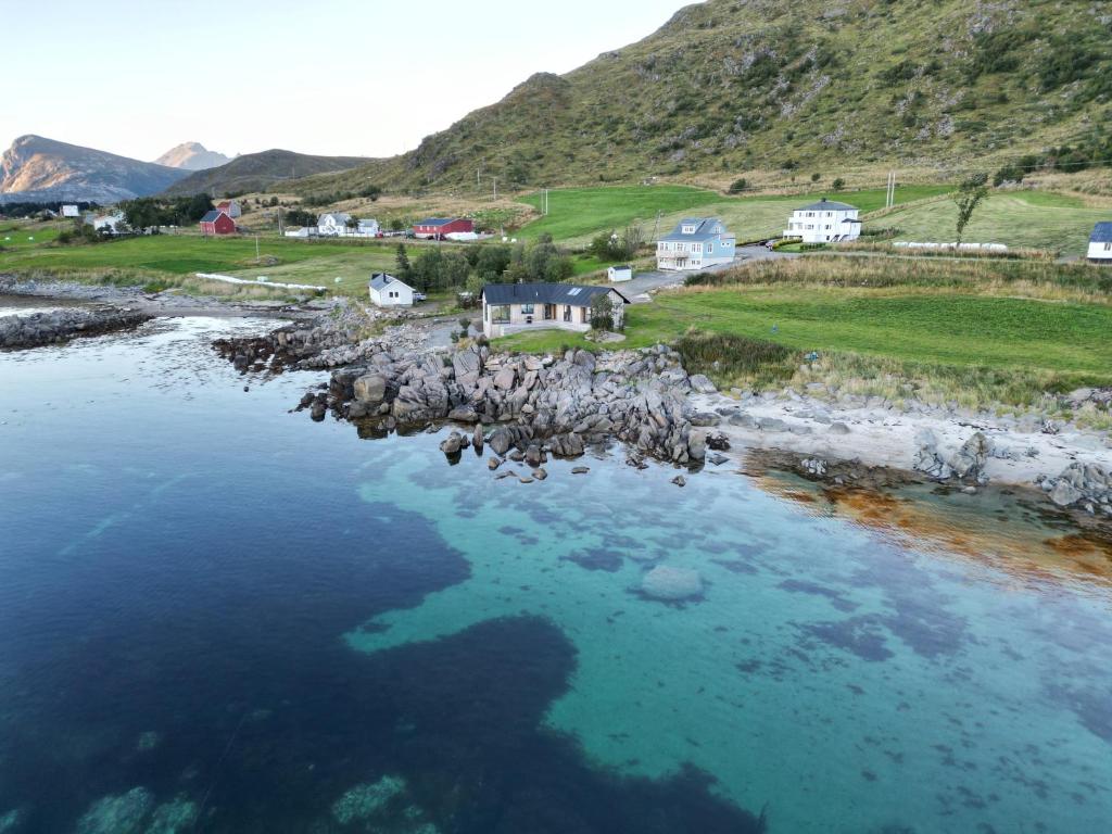 an aerial view of a body of water with houses at Superior Cabin with Private Beach Lofoten 