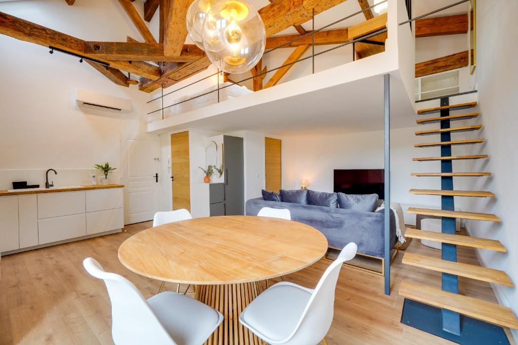 Il dispose d'une cuisine et d'un salon avec une table en bois et des chaises blanches. dans l'établissement LE MELI MELO - Superbe T2 - Bail Mobilité, à Bordeaux