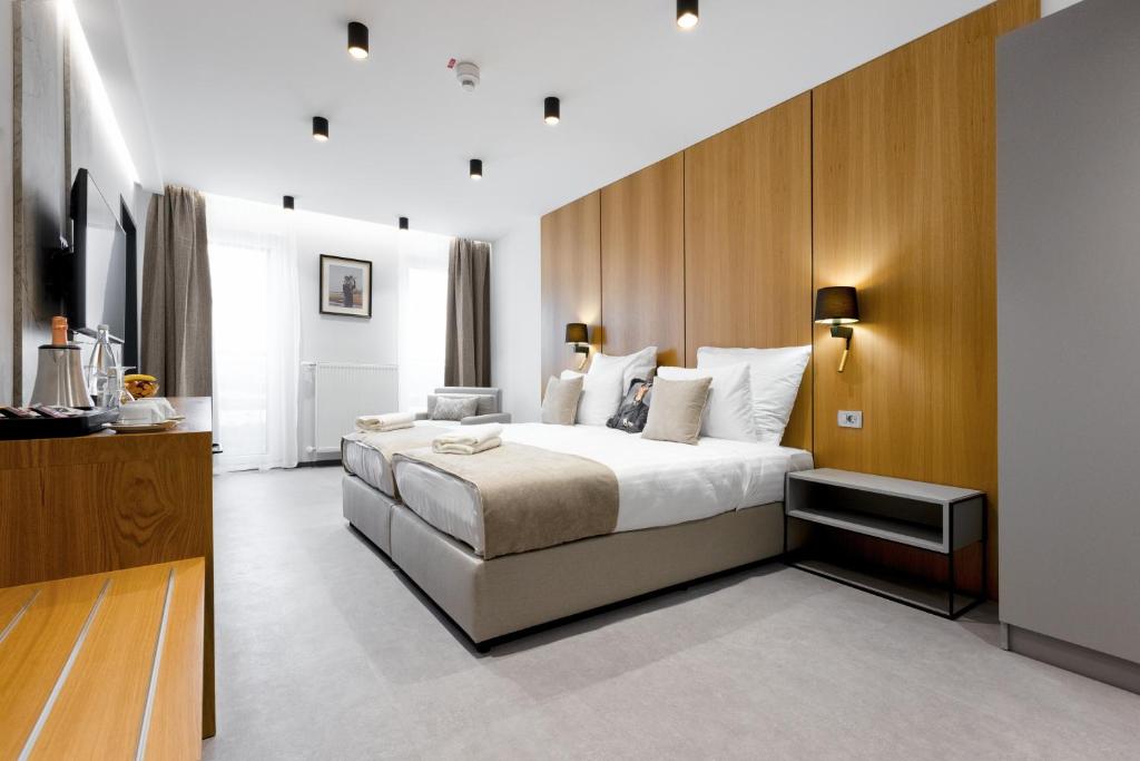 a bedroom with a large bed with a wooden wall at Victoria Interpark Hotel in Offenbach an der Queich