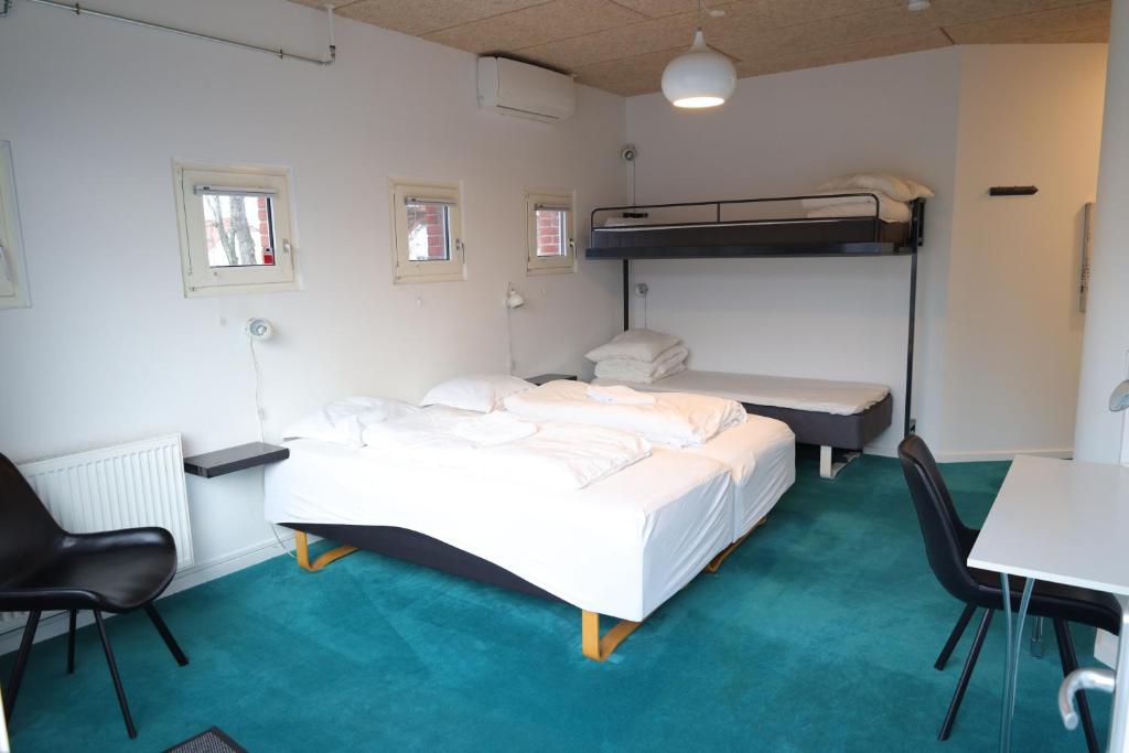 1 Schlafzimmer mit 2 Betten und 1 Etagenbett in der Unterkunft Motel Sindal in Sindal